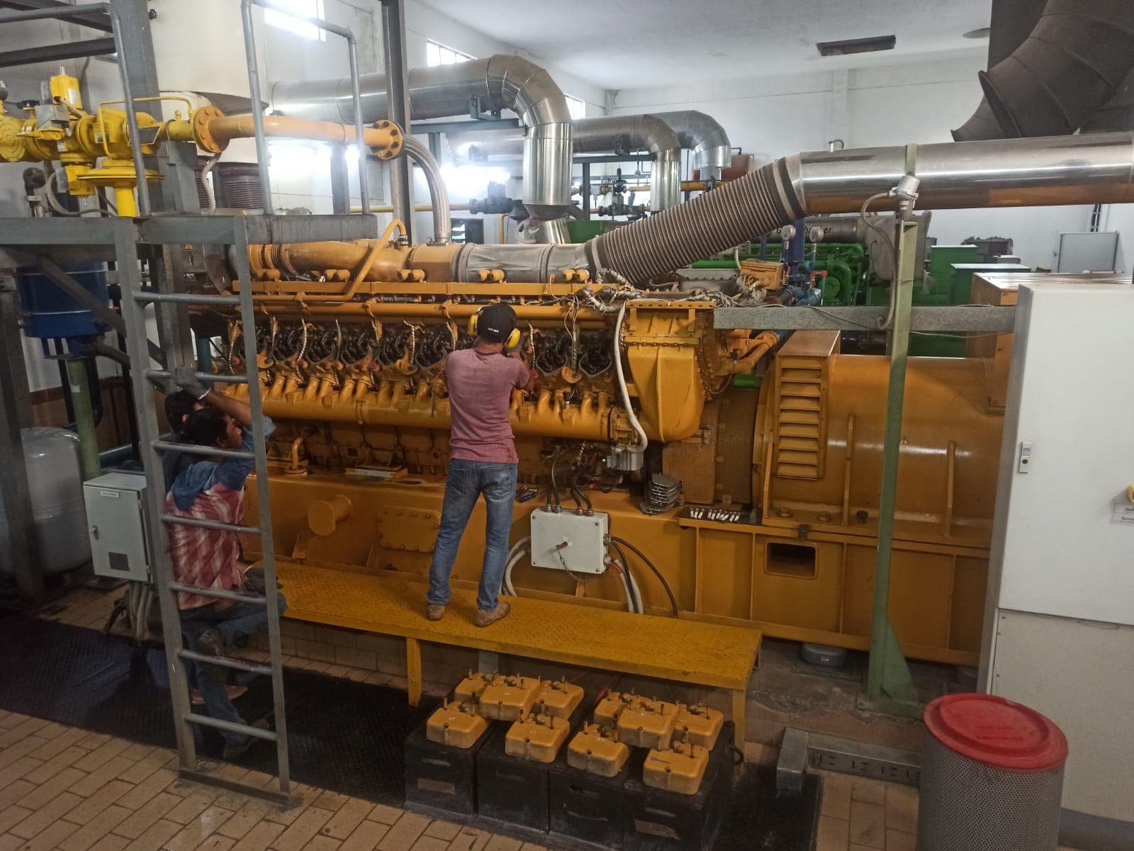 NPNES technician performing maintenance on a large engine